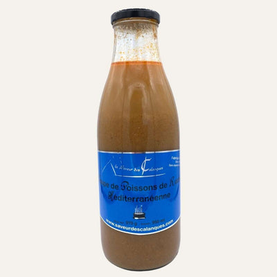 Bouteille de soupe de poissons de roche de Méditerranée sur fond crème, avec étiquette bleue.